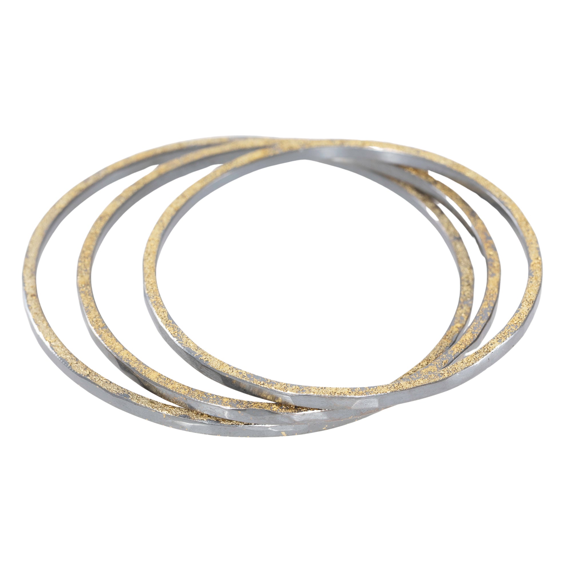 Three gold bracelets stacked on a white background