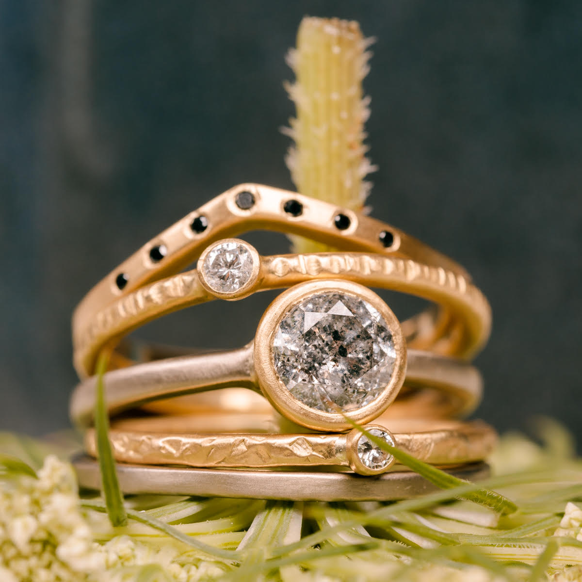 stack of handmade gold and diamond engagement rings and wedding bands custom designed by Kate Maller Jewelry in Denver Colorado