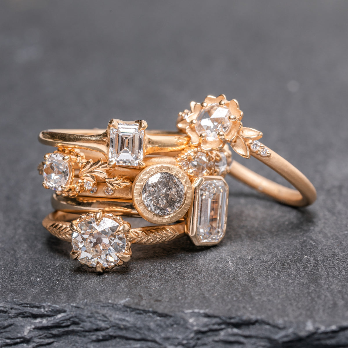 stack of handmade gold engagement rings with floral motifs and white diamonds custom designed by Kate Maller Jewelry in Denver Colorado